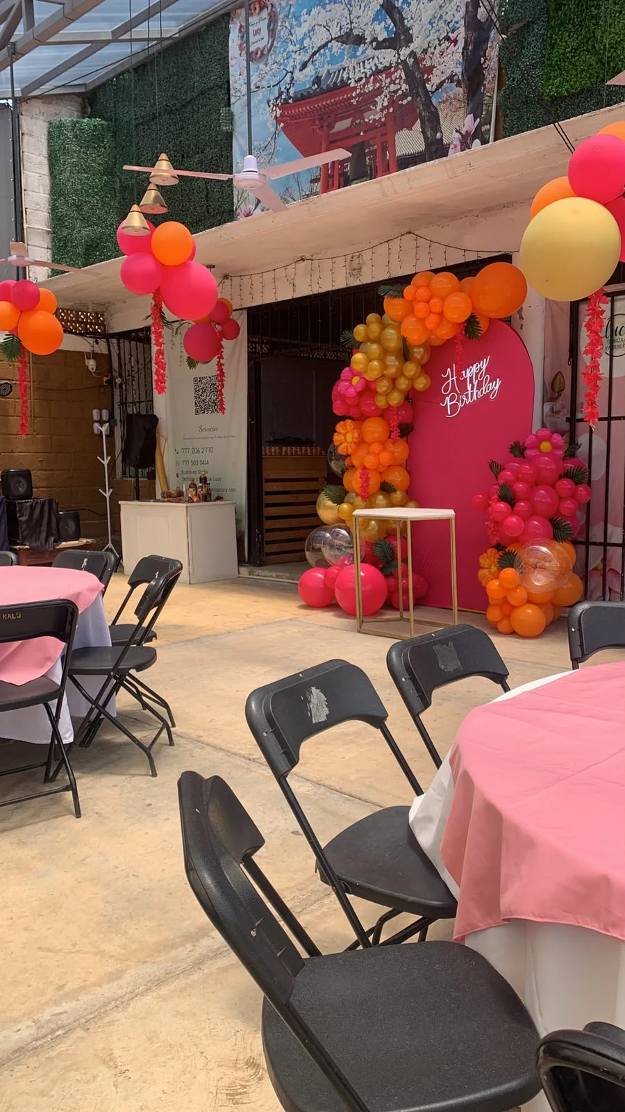 Decoración de cumpleaños con globos rosas, naranjas y amarillos