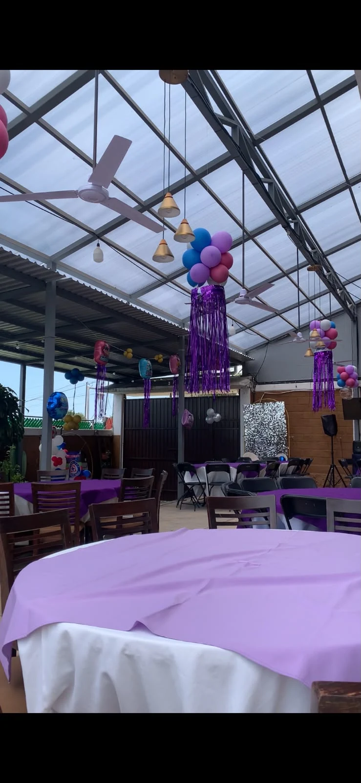 Terraza con mesas y decoración en tonos morados