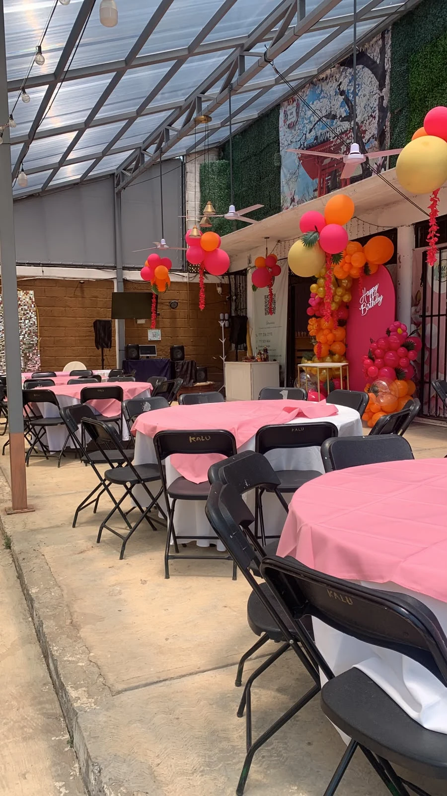 Mesas con mantelería rosa y decoración de cumpleaños en la terraza Lucy